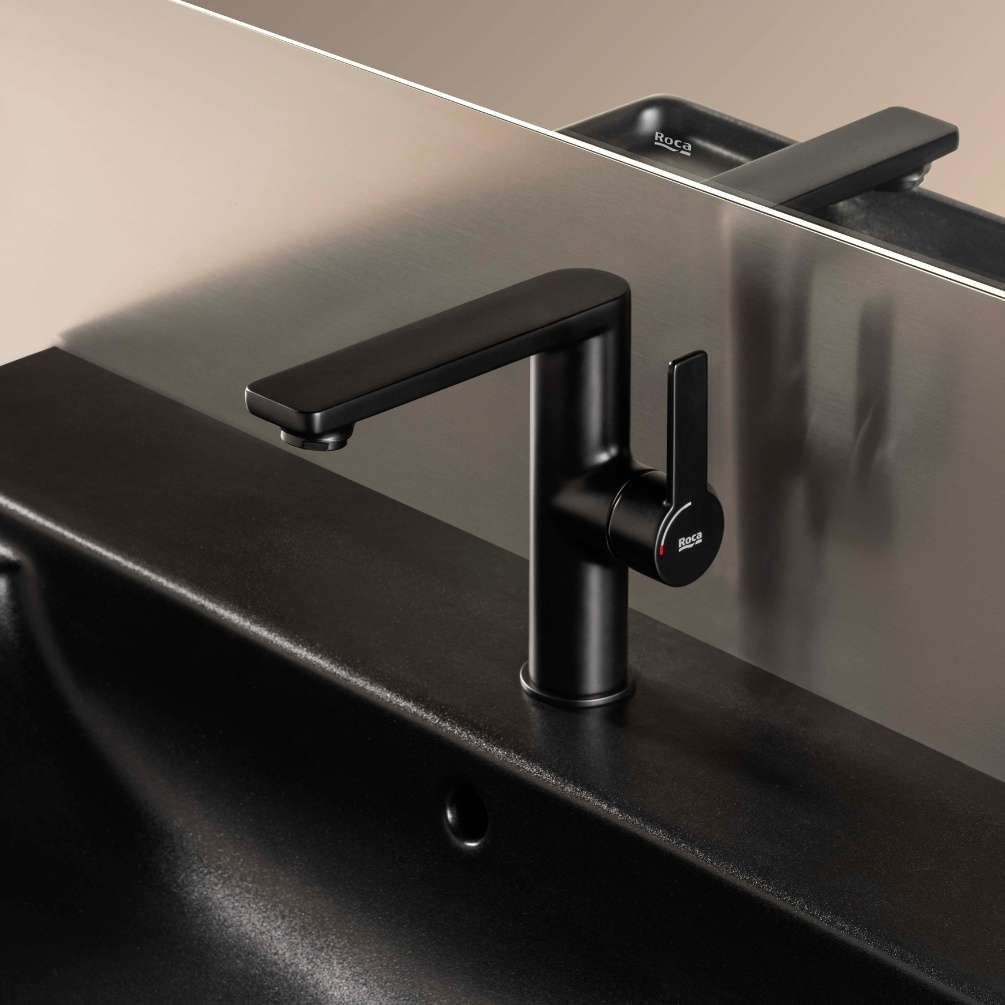 Lifestyle image of Roca Targa Matt Black Basin Mixer Tap with Side Handle installed on a black basin